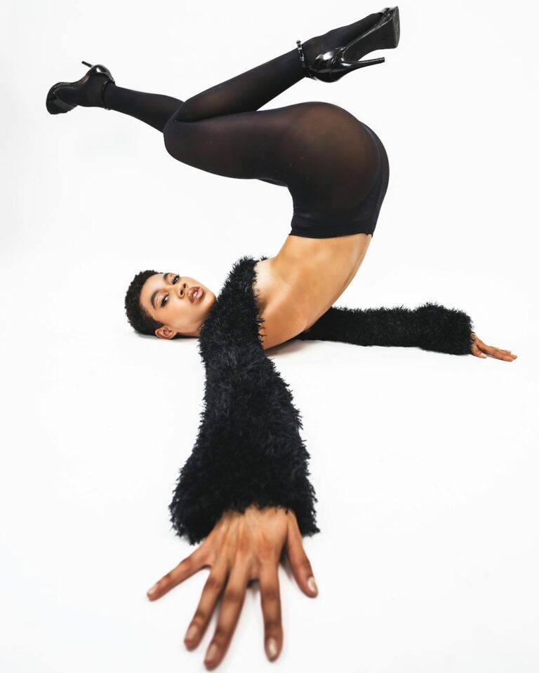 modern studio shot of a woman in black tights heels and a short sweater